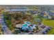 Scenic aerial view of the community featuring lush green spaces, a pool, and a lake in the distance at 12820 Bent Twig Dr, Riverview, FL 33579