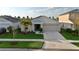 Charming single Gathering home features a well maintained lawn with lush landscaping and attached two car garage at 12820 Bent Twig Dr, Riverview, FL 33579
