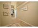 Hallway featuring neutral walls, light colored wood floors, a tan carpet runner, and beach themed decorations at 12820 Bent Twig Dr, Riverview, FL 33579