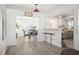 Open-concept living and dining area with gray chairs, wood floors, and a view into the kitchen at 1524 78Th N Ter, St Petersburg, FL 33702