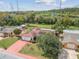 Aerial view of home showcasing lush backyard with canal access, solar panels, and neighboring houses at 1629 Dartmouth Dr, Holiday, FL 34691