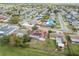 Aerial shot displays a neighborhood home featuring solar panels, a fenced backyard, and a screened-in enclosure at 1629 Dartmouth Dr, Holiday, FL 34691
