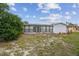 Enjoy outdoor living in this home's backyard featuring a well-maintained lawn and a sunroom with ample windows at 1629 Dartmouth Dr, Holiday, FL 34691