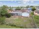 Backyard view of home with solar panels, a sunroom, and a partially fenced yard at 1629 Dartmouth Dr, Holiday, FL 34691