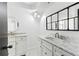 Bathroom with double vanity, marble countertop, and mirrors at 1629 Dartmouth Dr, Holiday, FL 34691