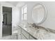 Well-lit bathroom features a white marble vanity, a decorative mirror, and tile flooring at 1629 Dartmouth Dr, Holiday, FL 34691