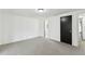 Neutral-carpeted bedroom features white walls and contrasting black door at 1629 Dartmouth Dr, Holiday, FL 34691