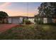 Charming single-story home featuring a well-maintained lawn and inviting curb appeal at dusk at 1629 Dartmouth Dr, Holiday, FL 34691