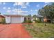 Charming single-story home with a garage, red driveway, and well-maintained landscaping at 1629 Dartmouth Dr, Holiday, FL 34691