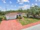Charming single-story home featuring a well-manicured lawn, and a red driveway and walkway at 1629 Dartmouth Dr, Holiday, FL 34691