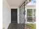 Close-up of the secure, black front door and decorative ironwork detail on front porch at 1629 Dartmouth Dr, Holiday, FL 34691