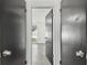 Hallway with three black doors, tile flooring, and a view to a window with natural light at 1629 Dartmouth Dr, Holiday, FL 34691