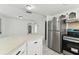 Open kitchen features stainless steel refrigerator and appliances, flowing to additional rooms at 1629 Dartmouth Dr, Holiday, FL 34691