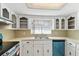 Kitchen featuring tile backsplash, stainless steel double sink, and white cabinets at 1629 Dartmouth Dr, Holiday, FL 34691