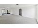 Spacious living room with neutral carpet, white walls, and access to the patio at 1629 Dartmouth Dr, Holiday, FL 34691