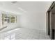 Bright living room with white brick wall, tiled floor, and sliding glass doors to the outside at 1629 Dartmouth Dr, Holiday, FL 34691