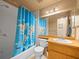 Bathroom with a shower/tub combo, a blue shower curtain featuring a world map, and a wood vanity at 16644 Vallely Dr, Tampa, FL 33618