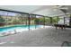 Spacious screened-in patio with a pool table and a view of the backyard pool at 16644 Vallely Dr, Tampa, FL 33618