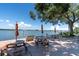 Community patio with tables and benches under the shade of a mature oak tree at 1847 Shore S Dr # 215, South Pasadena, FL 33707