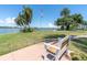 Scenic waterfront grounds feature a cozy bench under the shade of palm trees, inviting relaxation by the water's edge at 1847 Shore S Dr # 215, South Pasadena, FL 33707