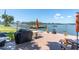 A waterfront patio offers a relaxing outdoor space with grill, furniture, and serene views of the water and passing boats at 1847 Shore S Dr # 215, South Pasadena, FL 33707