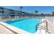 A pristine community pool sparkles in the sun next to the complex, framed by tropical palms and a secure fence at 1847 Shore S Dr # 215, South Pasadena, FL 33707