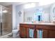 Bathroom featuring double sink, framed mirror, and glass-enclosed shower with neutral tile surround at 2831 Santego Bay Ct, Brandon, FL 33511