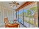 Enclosed balcony with seating offers a view of palm trees and the street at 3100 Gulf Blvd # 134, Belleair Beach, FL 33786