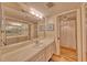 Bathroom featuring a large mirror over a vanity and tiled flooring, complemented by a shower with a curtain at 3100 Gulf Blvd # 134, Belleair Beach, FL 33786