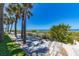 Relaxing beach access with shade trees and a walking path leading to the sandy shore at 3100 Gulf Blvd # 134, Belleair Beach, FL 33786