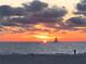 Picturesque beach sunset with a sailboat silhouetted against a fiery sky at 3100 Gulf Blvd # 134, Belleair Beach, FL 33786