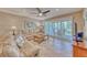 Light-filled living room includes a ceiling fan and sliding door access to the balcony at 3100 Gulf Blvd # 134, Belleair Beach, FL 33786
