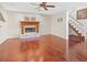 Hardwood floors and a cozy fireplace are featured in this living room with an adjacent staircase at 3114 Samara Dr, Tampa, FL 33618