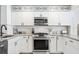Well-equipped kitchen featuring stainless steel appliances, granite counters, and modern white cabinetry at 3316 W Ballast Point Blvd, Tampa, FL 33611