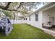 Well-maintained backyard with artificial grass, a climbing structure, and mature trees, ideal for outdoor activities at 3405 W Cherry St, Tampa, FL 33607