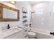 Bathroom features white vanity with framed mirror, shelves, and shower-tub combo at 3405 W Cherry St, Tampa, FL 33607