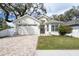 Charming single-story home with a brick driveway, lush lawn, and neutral-toned exterior paint at 3405 W Cherry St, Tampa, FL 33607