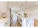 Bright white kitchen showcasing a large island, wood flooring, and modern light fixtures at 3405 W Cherry St, Tampa, FL 33607