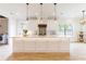Modern kitchen features an island with pendant lights, white cabinets, and stainless steel appliances at 3405 W Cherry St, Tampa, FL 33607