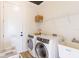 Clean laundry room with washer, dryer, sink and storage shelves, providing convenience and organization at 3405 W Cherry St, Tampa, FL 33607
