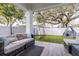 Covered patio with comfortable seating, artificial grass, and backyard play area, perfect for relaxation and entertainment at 3405 W Cherry St, Tampa, FL 33607
