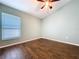 Bedroom with wood-look flooring, ceiling fan, a window and neutral paint at 3810 Chaucer Way, Land O Lakes, FL 34639