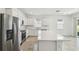 Open-concept kitchen with white cabinets, stainless steel appliances, and a quartz island overlooking living area at 4275 Big Sky Dr, Spring Hill, FL 34604