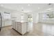 Open-concept kitchen with white cabinets, stainless steel appliances, and a quartz island overlooking living area at 4275 Big Sky Dr, Spring Hill, FL 34604
