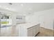 Open-concept kitchen with white cabinets, stainless steel appliances, and a quartz island overlooking living area at 4275 Big Sky Dr, Spring Hill, FL 34604