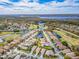 Aerial view of a community with homes situated around a lake and golf course at 4372 Water Oak Way, Palm Harbor, FL 34685