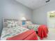 Cozy bedroom featuring twin beds with colorful bedding and adjacent bathroom at 4372 Water Oak Way, Palm Harbor, FL 34685