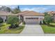 Charming home featuring a tile roof, an attached two-car garage, and a well manicured lawn at 4372 Water Oak Way, Palm Harbor, FL 34685