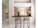 This view features seating at a bar looking into a kitchen with wood cabinetry and lots of light at 4372 Water Oak Way, Palm Harbor, FL 34685