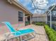 Comfortable chaise lounge on a brick patio with screened enclosure at 4372 Water Oak Way, Palm Harbor, FL 34685